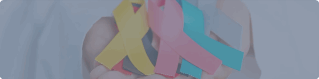 Cintas de colores que representan distintos tipos de cancer sostenidas en una mano como símbolo de concientización