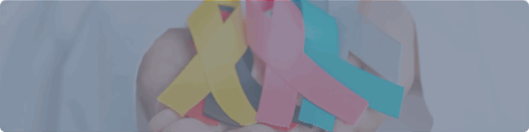 Cintas de colores que representan distintos tipos de cancer sostenidas en una mano como símbolo de concientización