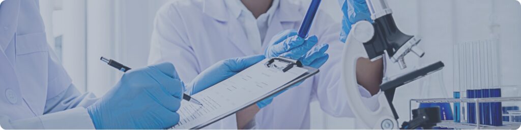 Profesionales de salud realizando un estudio clínico oncológico en laboratorio, con muestras y equipo médico especializado en cancer y estudios clinicos