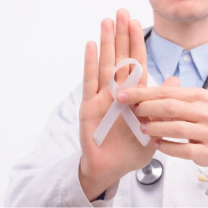 Médico sosteniendo cinta blanca en apoyo a la investigación clínica en cáncer